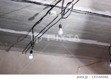 Industrial atmosphere with hanging lights and incomplete electrical installations 135584088