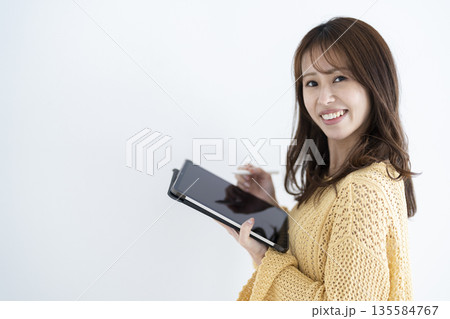 タブレットを持つ若い女性 135584767