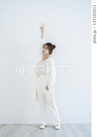 ピースサインをする女性 135585011