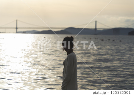 夕暮れの海を散策する女性 夕暮れの海を散策する女性 135585501