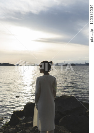 夕暮れの海を散策する女性 夕暮れの海を散策する女性 135585534