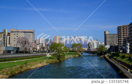 Morioka city overlooking snow-covered Mount Iwaki in Tohoku, Japan. Morioka city overlooking snow-covered Mount Iwaki in Tohoku, Japan. 135585746