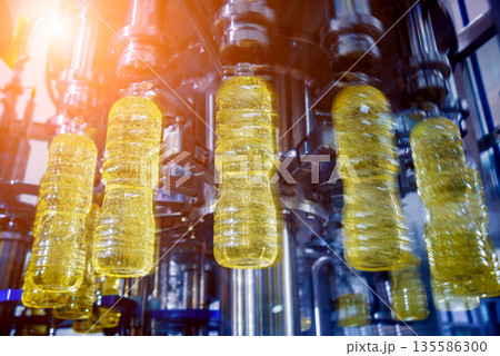 Bottling line of sunflower oil in bottles. Vegetable oil production plant Bottling line of sunflower oil in bottles. Vegetable oil production plant 135586300