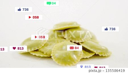 Displaying pile of green ravioli sitting on studio counter, with social media icon overlays Displaying pile of green ravioli sitting on studio counter, with social media icon overlays 135586419