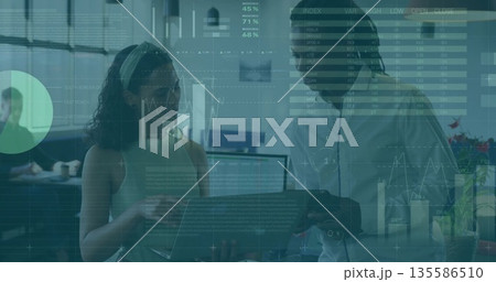 Analyzing laptop coworkers wearing sleeveless top, button-up shirt at office, with data overlays Analyzing laptop coworkers wearing sleeveless top, button-up shirt at office, with data overlays 135586510