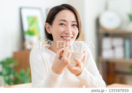 リビングで食事をするミドルの女性 135587050