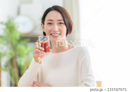 家でトマトジュースを飲むミドルの女性 家でトマトジュースを飲むミドルの女性 135587071