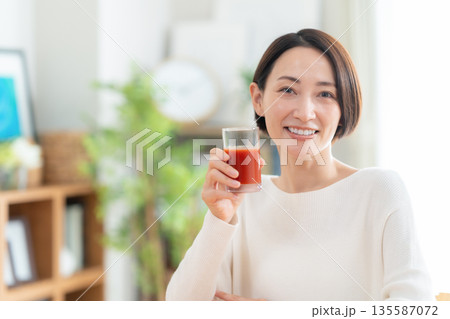 家でトマトジュースを飲むミドルの女性 家でトマトジュースを飲むミドルの女性 135587072