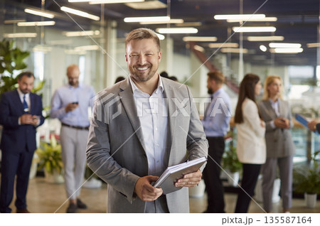 Portrait of smiling business leader or ceo in suit standing in conference room on business meeting. 135587164