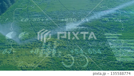 Spraying mobile sprinklers watering crop rows in rural farmland, with digital interface overlay 135588774