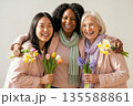 Joyful Diverse Women Celebrating Spring with Fresh Flower Bouquets 135588861