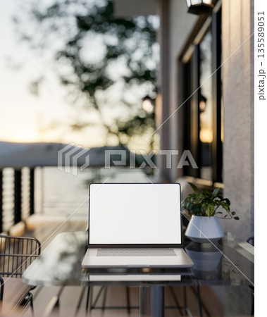 White screen laptop and potted plants on glass table at wooden floor balcony or terrace of a house. White screen laptop and potted plants on glass table at wooden floor balcony or terrace of a house. 135589051