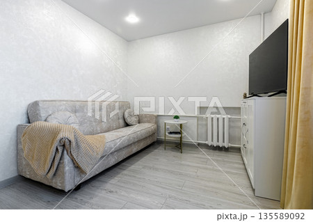 Bright living room interior with beige sofa and TV on white cabinet Bright living room interior with beige sofa and TV on white cabinet 135589092