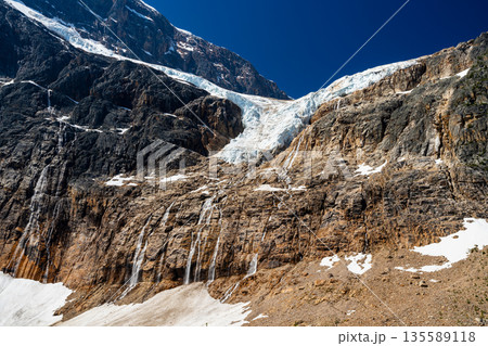 イーディス・キャベル山の断崖にかかるエンジェル氷河と融解水の池。アルバータ州、カナダ 135589118