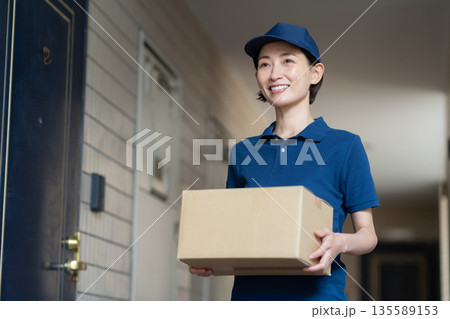 荷物を配達するミドルの女性配達員 135589153