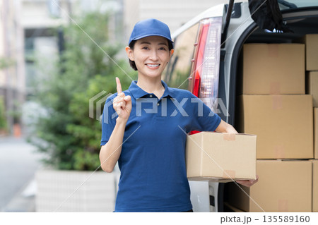 車で荷物を配達するミドルの女性配達員 135589160