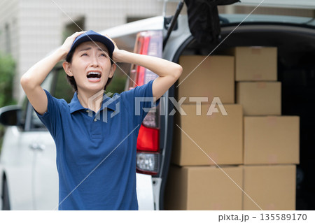 車で荷物を配達するミドルの女性配達員 135589170