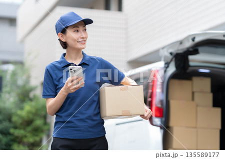 車で荷物を配達するミドルの女性配達員 135589177