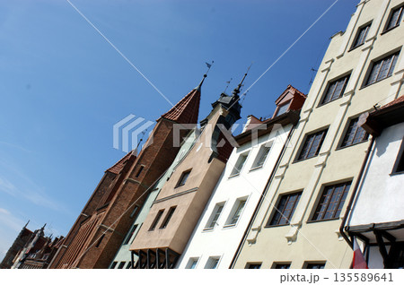 Old town square buildings lit by the sun in a row, people in the market square Poland Old town square buildings lit by the sun in a row, people in the market square Poland 135589641