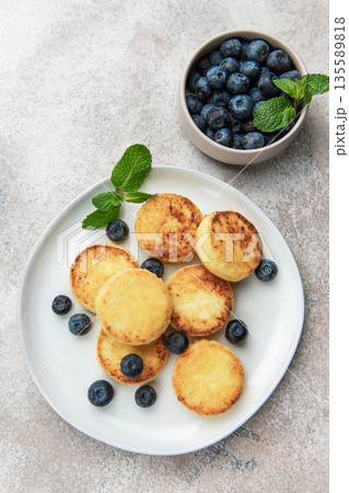 Syrniki cottage cheese pancakes with blueberries and mint 135589818