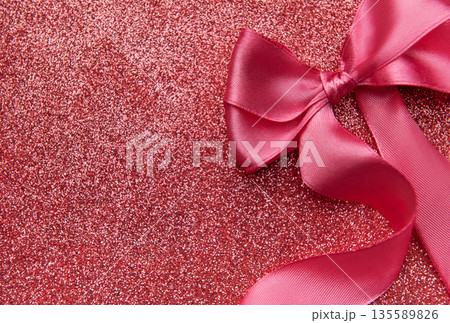 Pink ribbon bow on sparkling glitter background Pink ribbon bow on sparkling glitter background 135589826