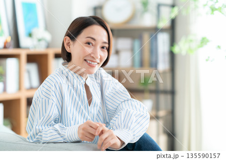 リビングのソファでくつろぐミドルの女性 リビングのソファでくつろぐミドルの女性 135590157