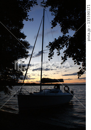 sunset sailing yacht sailboat moored on a dead lake 135590171
