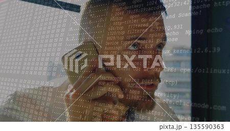 Talking on gold phone, engineer in checkered shirt gazing out office window, with network overlay 135590363