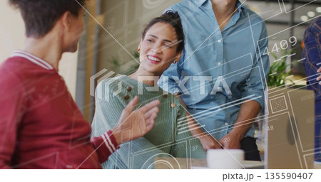 Brainstorming woman in green sweater guiding team in office meeting, with digital overlays and mug 135590407