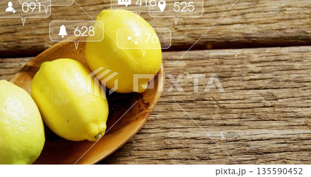 Resting three yellow lemons in bowl on rustic kitchen table overlaid social media icons copy space Resting three yellow lemons in bowl on rustic kitchen table overlaid social media icons copy space 135590452
