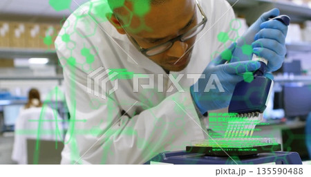 Pipetting technician wearing glasses loading 96-well microplate at lab bench with pipette 135590488