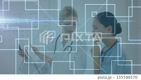 Studying medical chart and viewing digital overlays, doctors wearing scrubs, lab coat in clinic Studying medical chart and viewing digital overlays, doctors wearing scrubs, lab coat in clinic 135590570