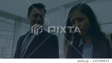 Sharing worried looks coworkers wearing suit in airport lobby with shoulder bag and gate 135590655