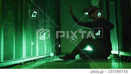 Interacting Korean tech wearing VR headset viewing CO2 metrics in server room, with floating icons Interacting Korean tech wearing VR headset viewing CO2 metrics in server room, with floating icons 135590738