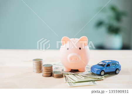 Piggy bank with car helps save money for auto insurance and fuel cost, refinance loan or finance drive and gas for transportation needs monthly budget planning with savings Piggy bank with car helps save money for auto insurance and fuel cost, refinance loan or finance drive and gas for transportation needs monthly budget planning with savings 135590931