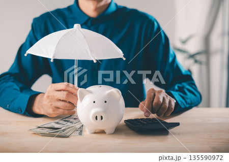 Piggy bank money protect financial insurance concept risk umbrella and finance collage shows man using calculator with cash to manage wealth safety and secure future savings 135590972