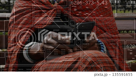 Holding smartphone man analyzing data overlays on park bench, wearing shirt, jeans, wrist bracelets 135591655