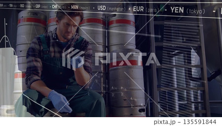 Inspecting worker wearing overalls adjusting glove on keg in storage area, with chart overlay 135591844