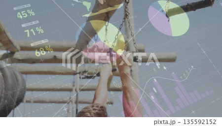Reaching man in tank top grabbing chain handle at fitness park, with wooden frame overlaid metrics 135592152