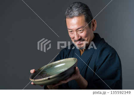 皿を持つ陶芸家の男性 皿を持つ陶芸家の男性 135592349