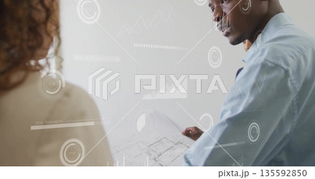 Standing male architect holding rolled blueprint in studio, with digital chart overlays, copy space Standing male architect holding rolled blueprint in studio, with digital chart overlays, copy space 135592850