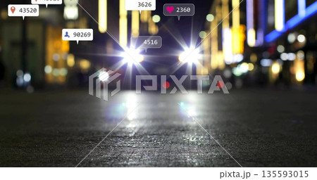 Shining vehicle headlights on wet street at night, overlays and neon signs glowing Shining vehicle headlights on wet street at night, overlays and neon signs glowing 135593015