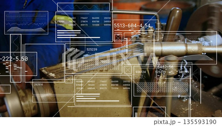Operating machinist wearing blue jacket and gloves machining part on lathe in shop with UI panels 135593190