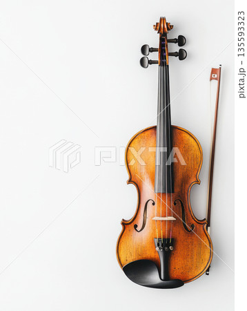 Elegant wooden violin with bow displayed against a plain white background highlighting its craftsmanship and intricate details 135593323