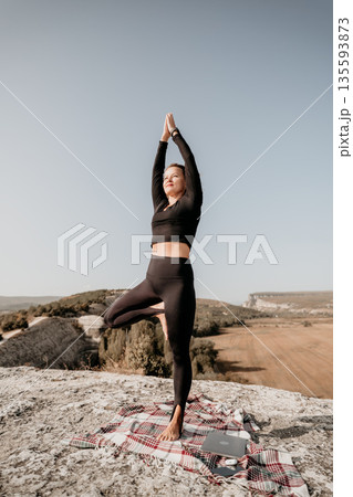 Woman Practicing Yoga on a Mountaintop Woman Practicing Yoga on a Mountaintop 135593873
