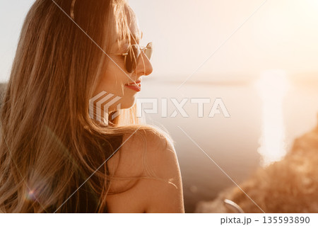 Woman sunset lake portrait of a smiling young woman wearing sunglasses enjoying a peaceful golden hour by the water Woman sunset lake portrait of a smiling young woman wearing sunglasses enjoying a peaceful golden hour by the water 135593890