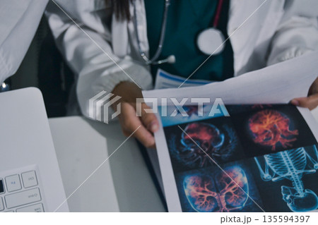 Doctor Explaining X-Ray Results to a Patient Using a Digital Device 135594397