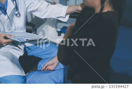 Man with abdominal pain, bloating, diarrhea goes to the doctor at medical clinic. Female doctor is diagnosing a patient abdominal pain in the examination room at the hospital. Man with abdominal pain, bloating, diarrhea goes to the doctor at medical clinic. Female doctor is diagnosing a patient abdominal pain in the examination room at the hospital. 135594427