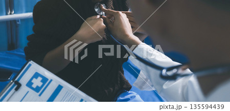 Caring doctor using stethoscope to examine patient heart during medical checkup Caring doctor using stethoscope to examine patient heart during medical checkup 135594439
