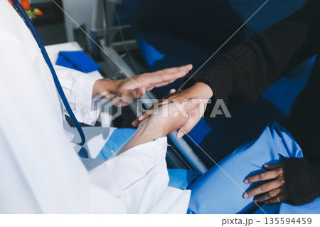 Doctor holding patient's hands offering comfort and support Doctor holding patient's hands offering comfort and support 135594459